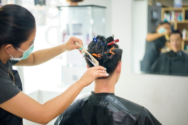 Un giovane si sta facendo tagliare i capelli in un parrucchiere