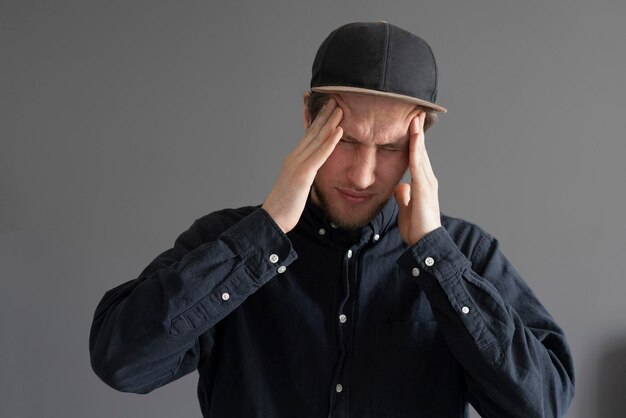 Un giovane si tocca la testa sentendo mal di testa e stress