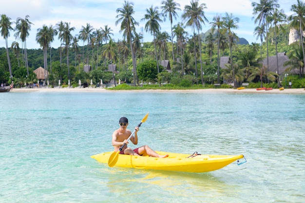 Un giovane sportivo in kayak sull'oceano in una giornata di sole