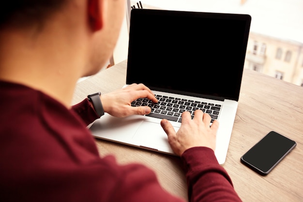 Un giovane sta lavorando al suo laptop