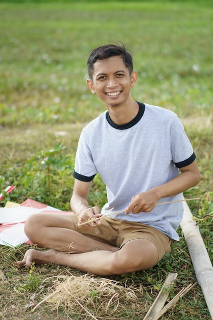 Un giovane sta preparando un bastone di bambù per un aquilone