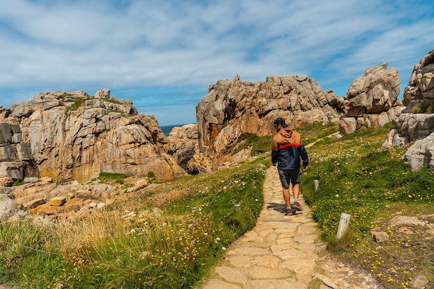 Un giovane turista a piedi i sentieri di Le Gouffre de Plougrescant, Cote de Granit Rose, Cotes d'Armor, Bretagna Francia