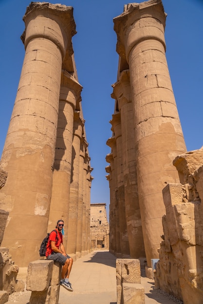 Un giovane turista accanto alle preziose colonne con disegni egizi nel Tempio di Luxor, in Egitto