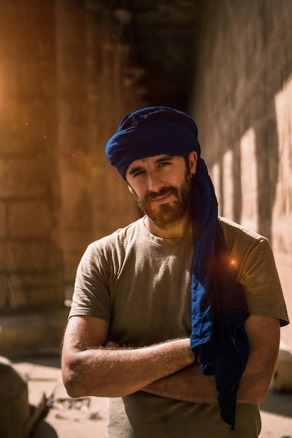 Un giovane turista con un turbante blu in visita al tempio di Edfu al mattino vicino alla città di Assuan