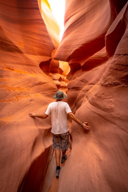 Un giovane turista con una camicia bianca in una fessura a Lower Antelope