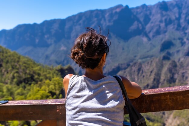 Un giovane turista guardando il paesaggio al Mirador de los Roques sul monte La Cumbrecita sull'isola di La Palma vicino alla Caldera de Taburiente, Isole Canarie. Spagna