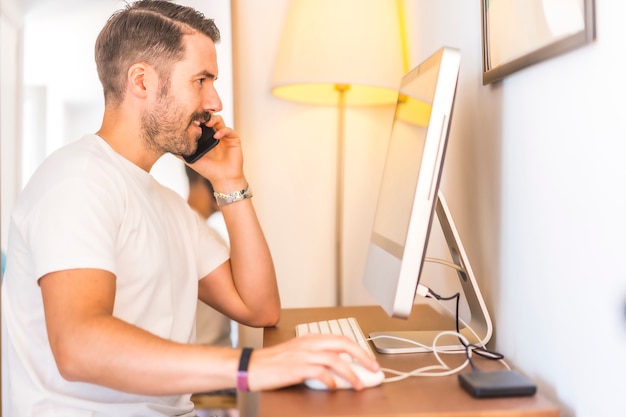 Un giovane uomo caucasico telelavoro a casa sul computer