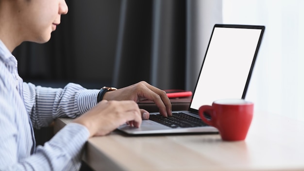 Un giovane uomo che utilizza il computer portatile che lavora in un nuovo progetto a casa.