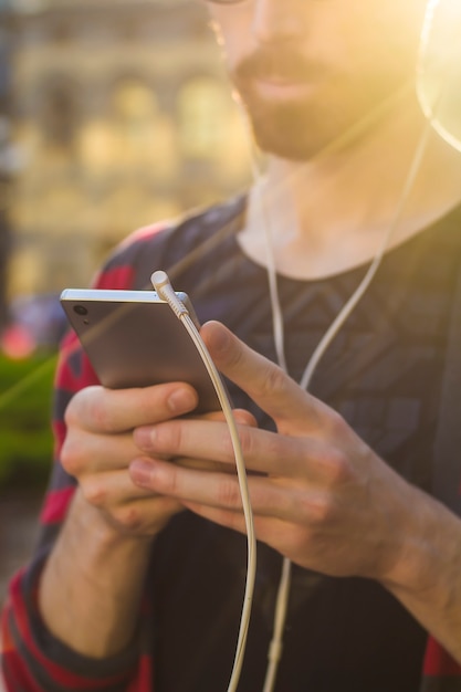 Un giovane uomo con la barba ascolta musica al telefono