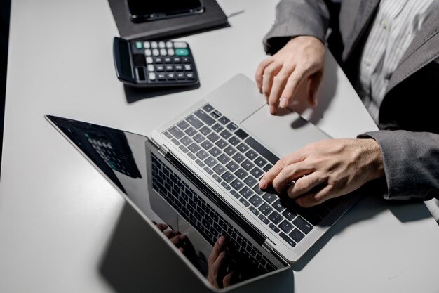 Un giovane uomo d'affari sta usando un portatile per cercare informazioni importanti sui concorrenti aziendali Un portatile è stato usato per accedere a documenti importanti da un dipendente