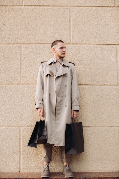 Un giovane uomo elegante con borse dopo lo shopping di successo il Black Friday