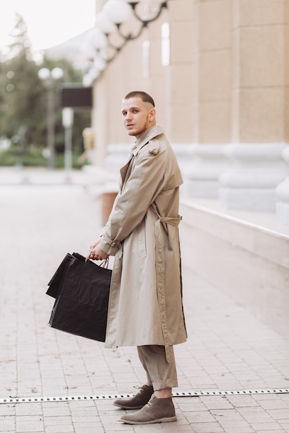 Un giovane uomo elegante con borse dopo lo shopping di successo il Black Friday