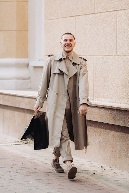 Un giovane uomo elegante con borse dopo lo shopping di successo il Black Friday