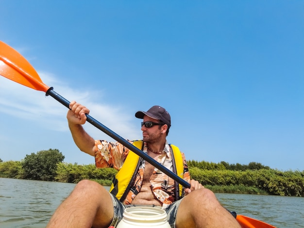 Un giovane uomo in canoa facendo canoa in un parco naturale della Catalogna, fiume vicino alla spiaggia di Estartit