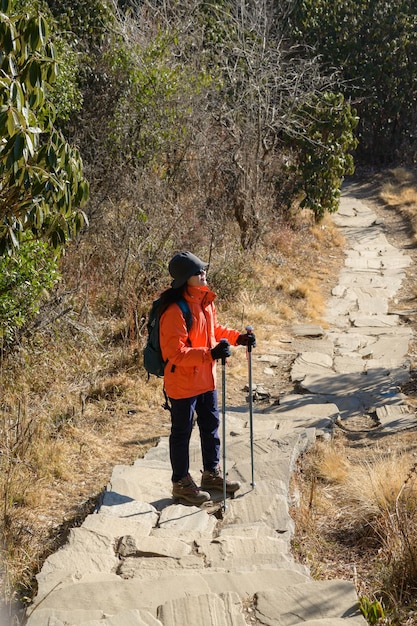 Un giovane viaggiatore che fa trekking sul sentiero forestale Nepal