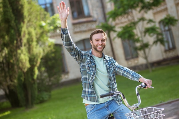 Un giro in bicicletta. Una foto di un giovane in camicia a quadri su una bicicletta