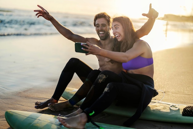 Un goffo surfista che si fa dei selfie su una spiaggia