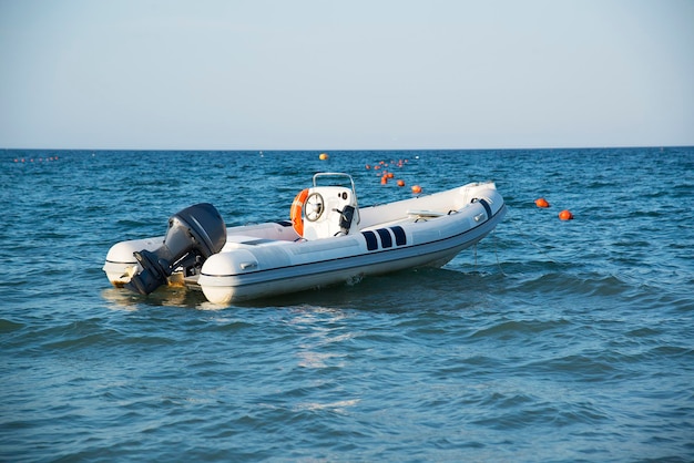 Un gommone con un motore in mare al tramonto