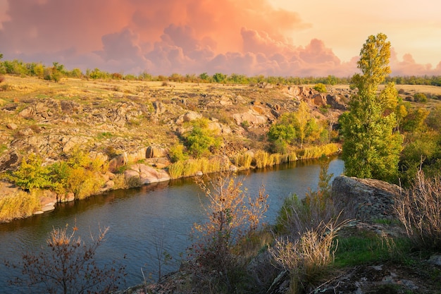 Un gran numero di minerali di pietra ricoperti di vegetazione che giace su un piccolo fiume nella pittoresca Ucraina