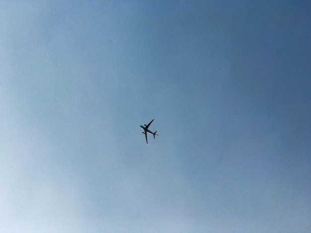 Un grande aereo passeggeri con le ali vola alto nel cielo blu