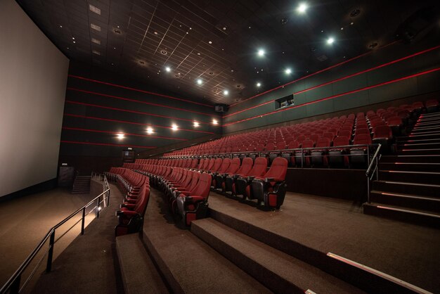 Un grande auditorium con sedili rossi e un corrimano che dice "sono un cinema"