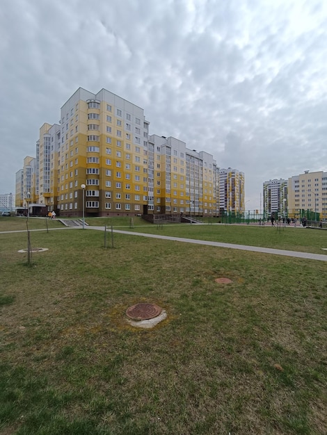 Un grande edificio con un prato verde e un edificio giallo con un cartello che dice "divieto di parcheggio"