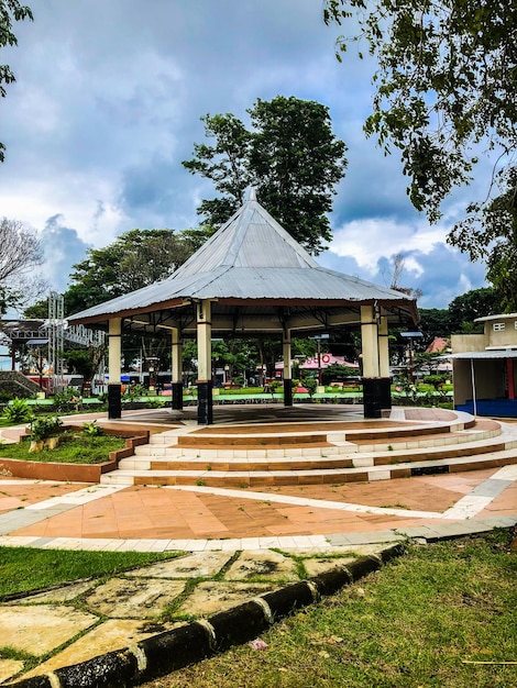 Un grande gazebo in un parco con un edificio sullo sfondo