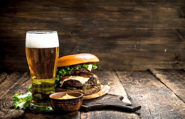 Un grande hamburger con carne di manzo e un bicchiere di birra