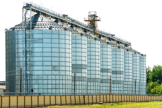 Un grande impianto moderno per lo stoccaggio e la lavorazione dei raccolti di grano vista del granaio in una giornata di sole contro il cielo blu Fine della stagione del raccolto