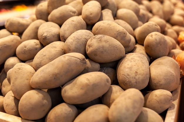 Un grande mucchio di patate fresche sul bancone di un negozio di alimentari