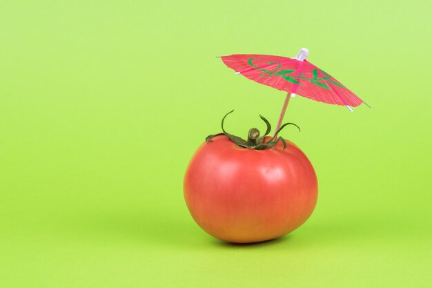 Un grande pomodoro fresco maturo su uno sfondo verde.