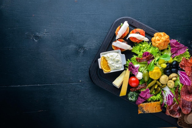 Un grande set di cucina italiana Carne di salsiccia di formaggio e verdure sottaceto su tavola di legno Vista dall'alto Spazio libero