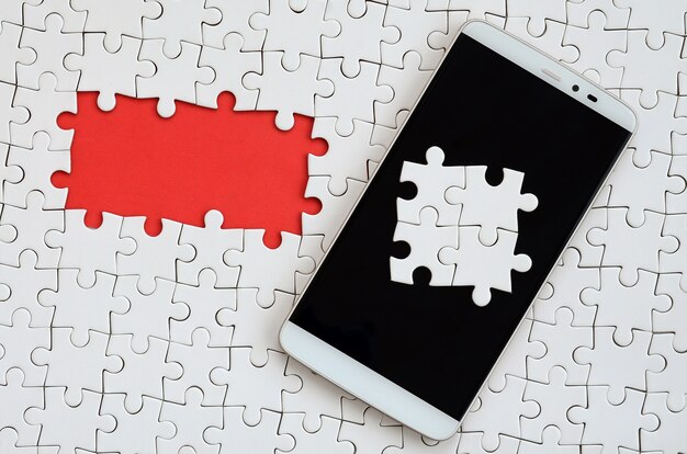 Un grande smartphone moderno con diversi elementi puzzle sullo schermo tattile