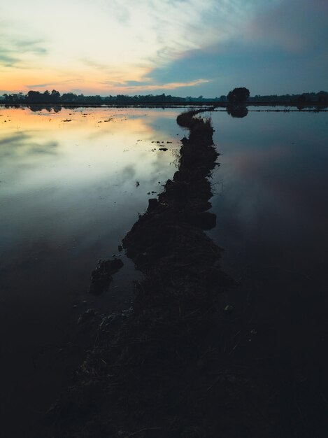 Un grande specchio d'acqua con un cielo blu sullo sfondo.