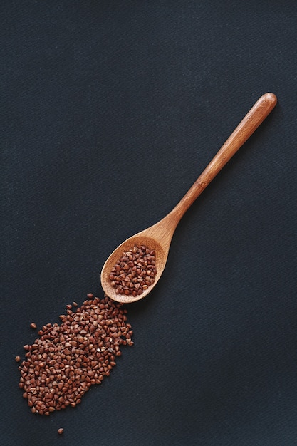 Un grano saraceno di cereali in cucchiaio di legno o bambù