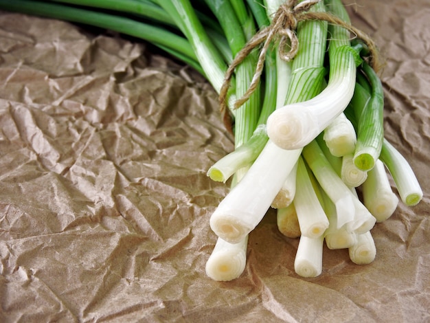 Un grappolo di cipolla verde su carta stropicciata.