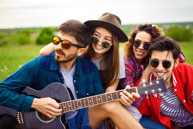 Un gruppo di amici che si divertono con le persone in festa tengono in mano le stelle filanti di Natale