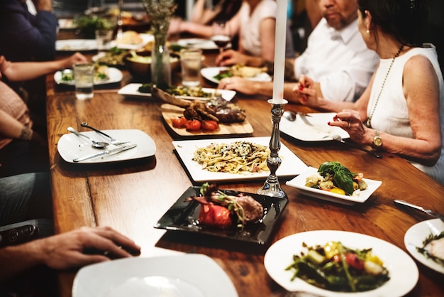 Un gruppo di amici diversi stanno cenando insieme