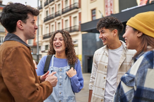 Un gruppo di amici entusiasti di diverse culture che ridono e si godono il loro arrivo a Madrid