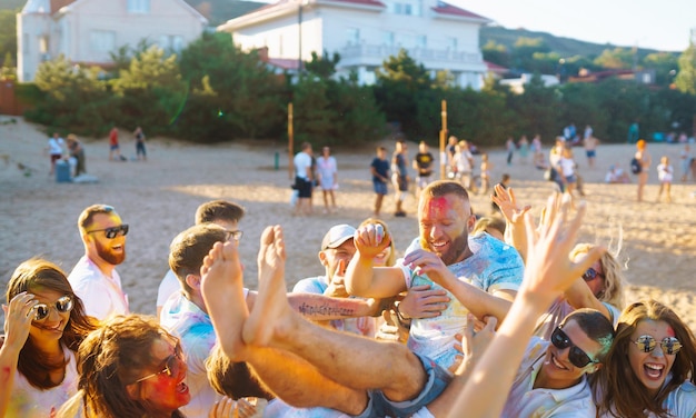 Un gruppo di amici si diverte a ballare al festival di Holi per celebrare la tradizionale festa indiana della primavera.