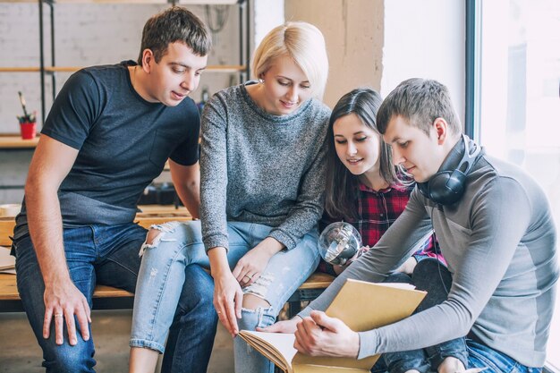 Un gruppo di amici studenti stanno facendo e discutendo idee creative nel loft