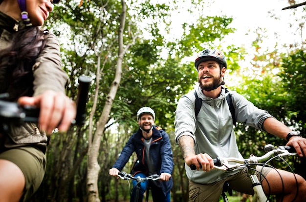 Un gruppo di amici va in mountain bike nella foresta insieme