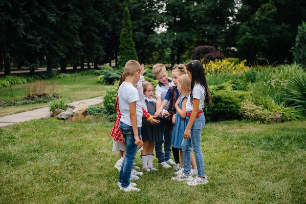 Un gruppo di bambini corre, si diverte e gioca come una squadra più numerosa in estate nel Parco. Infanzia felice.