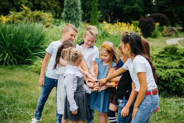 Un gruppo di bambini corre, si diverte e gioca in squadra in estate nel Parco. Infanzia felice.