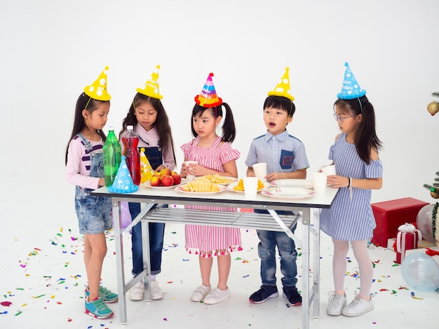 Un gruppo di bambini festeggia la festa e si divertono insieme a Natale, i bambini si scambiano i regali.