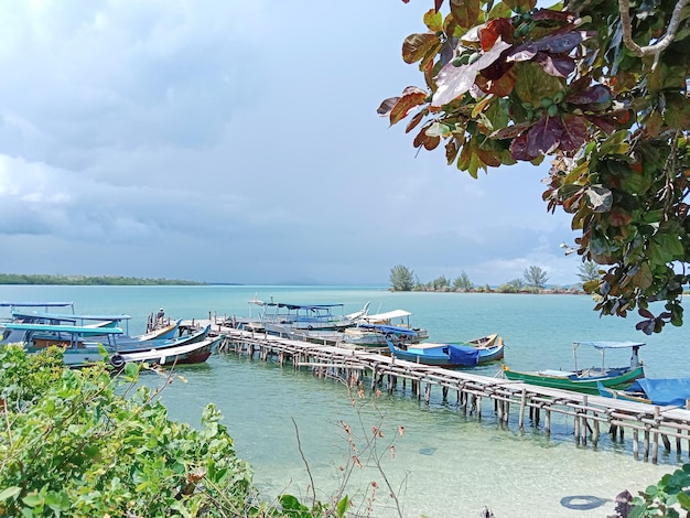 Un gruppo di barche di legno sono ormeggiate al molo di legno nel porto di Tanjung Ru a Belitung, Indonesia.