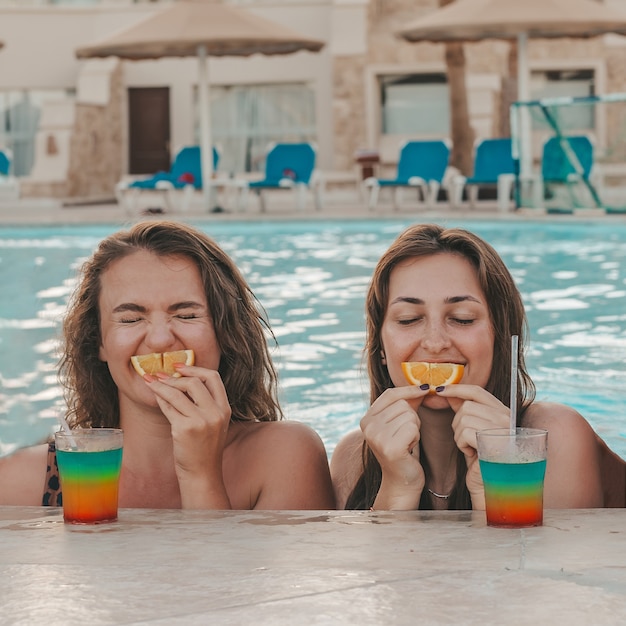 Un gruppo di belle giovani donne si riposa in piscina, gli amici si riposano in piscina