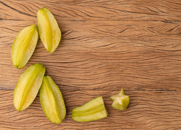 Un gruppo di carambola con fette su un tavolo di legno con spazio per la copia