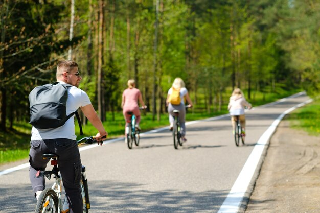 Un gruppo di ciclisti con zaini va in bicicletta su una strada forestale godendosi la natura.