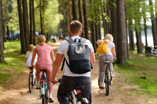 Un gruppo di ciclisti con zaini va in bicicletta su una strada forestale godendosi la natura.